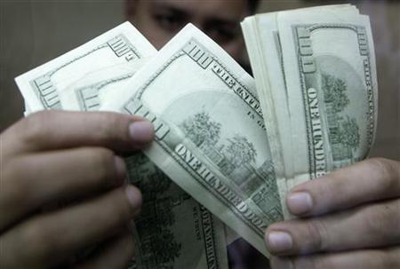 An employee checks dollar bills inside a money changer in Manila August 7, 2009. REUTERS/Cheryl Ravelo
An employee checks dollar bills inside a money changer in Manila August 7, 2009. REUTERS/Cheryl Ravelo