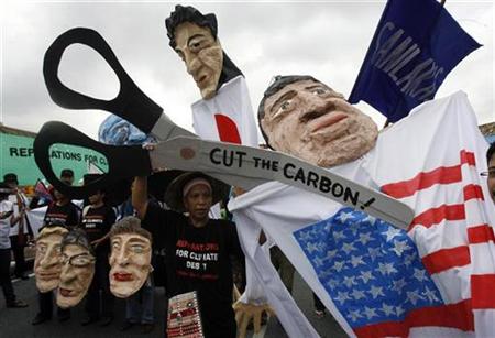




An activist pretends to cut off the head of an effigy of U.S. President Barack Obama during a demonstration outside the United Nations Building in Bangkok, where talks on climate change are being held, October 5, 2009. REUTERS/Chaiwat Subprasom

