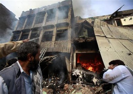 Men stand in front of a building after a bomb explosion in Peshawar, located in Pakistan's restive North West Frontier Province, October 28, 2009. REUTERS/Fayaz Aziz
Men stand in front of a building after a bomb explosion in Peshawar, located in Pakistan's restive North West Frontier Province, October 28, 2009. REUTERS/Fayaz Aziz