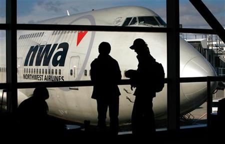 Passengers stand in front of a Northwest Airlines Boeing 747 at Detroit Metropolitan Wayne County Airport, February 6, 2006. REUTERS/John Gress
Passengers stand in front of a Northwest Airlines Boeing 747 at Detroit Metropolitan Wayne County Airport, February 6, 2006. REUTERS/John Gress