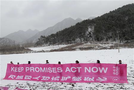 
Volunteers hold a banner near the Great Wall during a snowfall on the outskirts of Beijing November 12, 2009. REUTERS/Jason Lee
