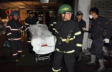 Firefighters evacuate the body of one of victims at the scene of a fire at an indoor shooting range in Busan, about 420 km (262 miles) southeast of Seoul November 14, 2009. REUTERS/Jo Jung-ho/Yonhap
Firefighters evacuate the body of one of victims at the scene of a fire at an indoor shooting range in Busan, about 420 km (262 miles) southeast of Seoul November 14, 2009. REUTERS/Jo Jung-ho/Yonhap