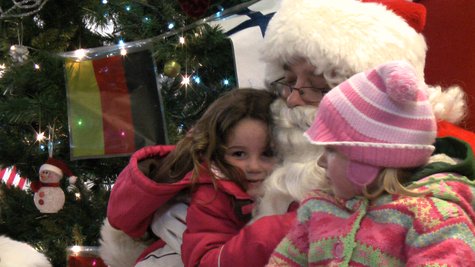 Local children enjoy Santa's visit to the "International Festival of Lights" warming house.