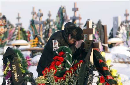 A friend of Timur Prokofiev, a victim of Friday's nightclub fire in Perm, grieves during his burial at a cemetery outside Perm, 1,150 km (720 miles) east of Moscow, December 6, 2009. REUTERS/Denis Sinyakov
A friend of Timur Prokofiev, a victim of Friday's nightclub fire in Perm, grieves during his burial at a cemetery outside Perm, 1,150 km (720 miles) east of Moscow, December 6, 2009. REUTERS/Denis Sinyakov