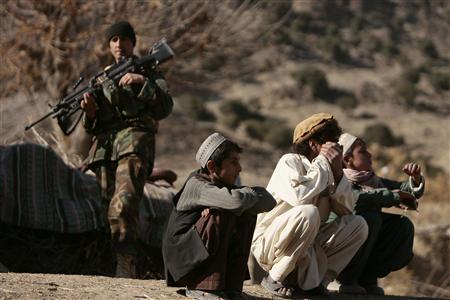 
An Afghan soldier secures the area as boys watch U.S Army soldiers from Task Force Yukon 1-40 CAV combat team meet village elders in Khowst province, Afghanistan, December 7, 2009. REUTERS/Zohra Bensemra
