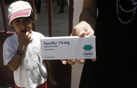 A boy looks at a woman holding out a box of Tamiflu as she talks with journalists outside a school in Lisbon July 7, 2009. REUTERS/Nacho Doce
A boy looks at a woman holding out a box of Tamiflu as she talks with journalists outside a school in Lisbon July 7, 2009. REUTERS/Nacho Doce