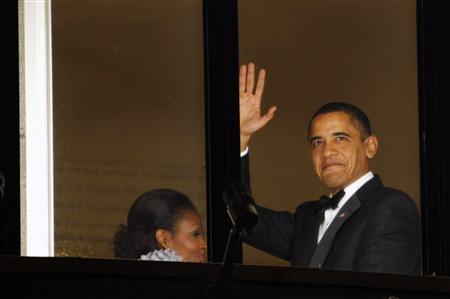 
U.S. President Barack Obama gives a final wave as he and his wife Michelle depart the balcony of the Grand Hotel in Oslo to attend the Nobel banquet December 10, 2009. REUTERS/Kevin Lamarque
