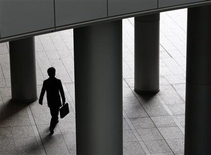 
A businessman walks past pillars in Tokyo December 14, 2009. REUTERS/Yuriko Nakao
