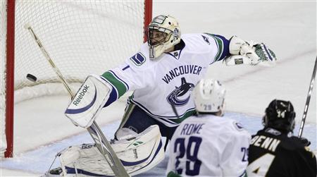 
Vancouver Canucks goalie Roberto Luongo deflects a shot against the Dallas Stars in the first period of their NHL hockey game in Dallas, Texas January 2, 2010. REUTERS/Tim Sharp
