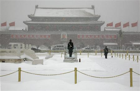 
Paramilitary policemen stand guard in front of the late Chairman Mao Zedong on a snow-covered Tiananmen Square in Beijing January 3, 2010. REUTERS/David Gray
