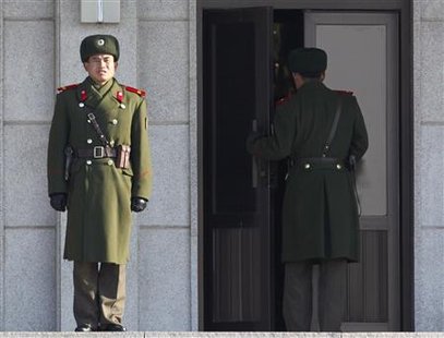 A North Korean soldier stands guards as a fellow soldier walks into the building on the north side of the truce village of Panmunjom in the demilitarised zone separating the two Koreas in Paju, about 55 km (34 miles) north of Seoul, January 21, 2010. REUTERS/Jo Yong-Hak
A North Korean soldier stands guards as a fellow soldier walks into the building on the north side of the truce village of Panmunjom in the demilitarised zone separating the two Koreas in Paju, about 55 km (34 miles) north of Seoul, January 21, 2010. REUTERS/Jo Yong-Hak