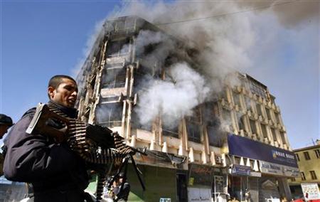 
An Afghan policeman stands in front of the shopping mall, where Taliban gunmen battled security forces for hours, as the government forces restored control after the attack in Kabul January 18, 2010. REUTERS/Omar Sobhani
