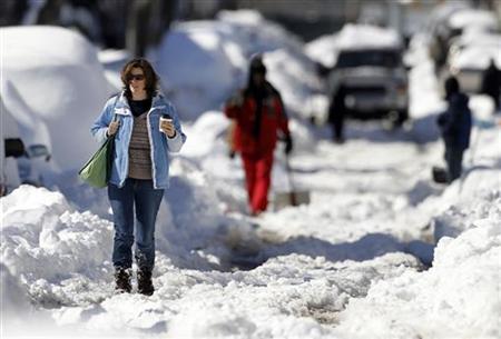 
A woman walks through heavy snow as she carries her coffee on Capitol Hill in Washington, February 11, 2010. REUTERS/Jason Reed
