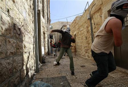 
A Palestinian throws a stone towards Israeli police during confrontations in Jerusalem's Old City February 28, 2010. REUTERS/Ammar Awad
