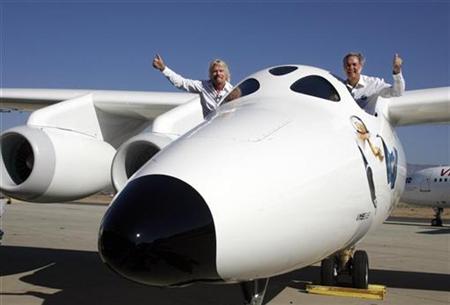 
Virgin Group's Founder billionaire Richard Branson (L) and Burt Rutan, president of Scaled Composites, wave from the window of Virgin Galactic's mothership WhiteKnightTwo during its public roll-out in Mojave, California July 28, 2008. REUTERS/Fred Prouser
