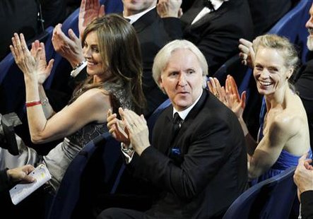 
Director James Cameron (C) and his wife Suzy Amis (R) applaud behind director Kathryn Bigelow after "Avatar" won the award for best art direction during the 82nd Academy Awards in Hollywood March 7, 2010. REUTERS/Gary Hershorn
