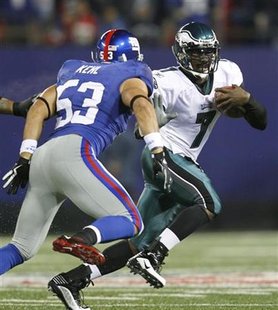 
Philadelphia Eagles' quarterback Michael Vick (R) runs with the ball away from the defense of New York Giants' Bryan Kehl during the second quarter of their NFL football game in East Rutherford, New Jersey December 13, 2009 file photo. REUTERS/Mike Segar
