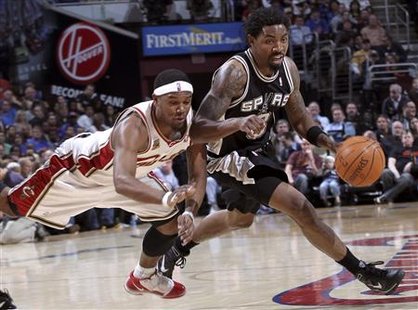 
San Antonio Spurs Roger Mason (R) eludes a diving Daniel Gibson of the Cleveland Cavaliers during the second quarter of their NBA basketball game in Cleveland March 8, 2010.REUTERS/Aaron Josefczyk
