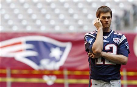 
New England Patriots quarterback Tom Brady talks on the phone during the team's walk through for the NFL's Super Bowl XLII football game in Glendale, Arizona, February 2, 2008 file photo. REUTERS/Shaun Best
