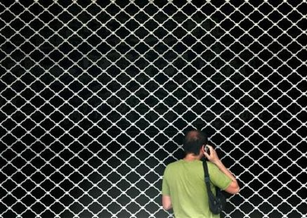 
A man speaks on the phone as he stands in front of a closed metro station during a 24 hour nationwide strike in Athens July 26, 2005. REUTERS/Yiorgos Karahalis
