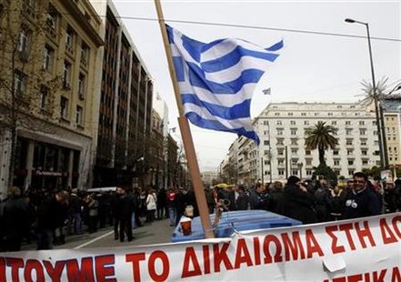 
Former employees of privatized Olympic Airways stand behind barricades in front of Greece's General Accountants office in Athens March 10, 2010. REUTERS/Yiorgos Karahalis
