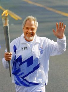 
Former star NFL football player Merlin Olsen carries the Olympic Flame during the Salt Lake Olympic Torch Relay, through Kearns, Utah, February 8, 2002 file photo. REUTERS/Pool/Todd Warshaw
