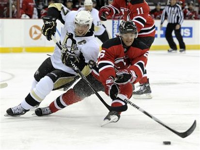 
Pittsburgh Penguins center Sidney Crosby (L) and New Jersey Devils defenseman Andy Greene chase the puck in the first period of their NHL hockey game in Newark, New Jersey, March 12, 2010. REUTERS/Ray Stubblebine
