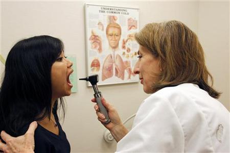 
Bonnary Lek, a manager at Discovery Communications headquarters, is examined by Discovery Wellness Center Medical Director Liz Sequeira during an appointment at the clinic in Silver Spring, Maryland December 3, 2009. REUTERS/Jim Bourg
