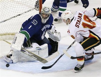 
Vancouver Canucks' Roberto Luongo (L) stops Calgary Flames' Matt Stajan during second period NHL play in Vancouver, British Columbia, March 14, 2010. REUTERS/Lyle Stafford
