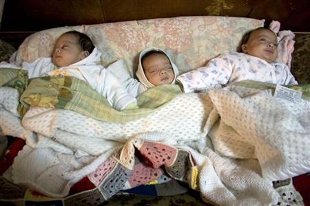 
Triplets are shown sleeping on a sofa in the living room of their grandparents' home in the town of Leones in Cordoba Province, northern Argentina, May 10, 2008. REUTERS/Carolina Camps
