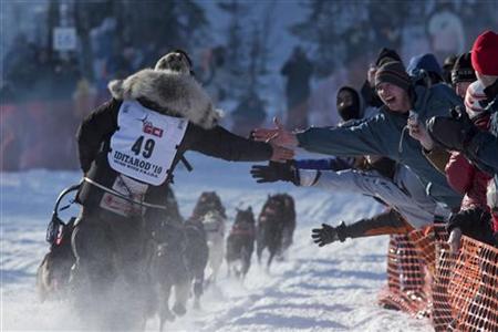 
Lance Mackey, winner of the Iditarod for the last three years, reaches out to fans while charging down the trail just after the official start of the 2010 Iditarod Race in Willow, Alaska March 7, 2010. REUTERS/Nathaniel Wilder
