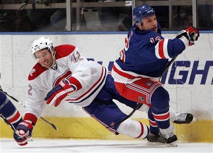 
New York Rangers Sean Avery (R) checks Montreal Canadiens Dominic Moore into the boards during the second period of their NHL hockey game at Madison Square Garden in New York March 16, 2010. REUTERS/Jessica Rinaldi
