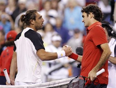 
Marcos Baghdatis (L) of Cyprus and Roger Federer of Switzerland shake hands after Baghdatis defeated him in their match at the Indian Wells ATP tennis tournament in Indian Wells, California, March 16, 2010. REUTERS/Danny Moloshok
