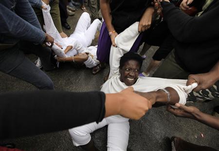 
Security forces drag members of the Ladies in White, a group made up of family members of imprisoned dissidents, into a bus after a march in Havana March 17, 2010. REUTERS/Desmond Boylan
