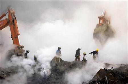 
Firefighters make their way over the ruins through clouds of smoke as work continues at ground zero in New York, one month after the attacks on the World Trade Center in this October 11, 2001 file photo. REUTERS/Stan Honda/POOL
