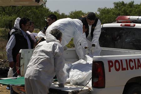 
Forensic personnel prepares to remove two bodies from the bed of a police truck, where they were found, in the town of General Trevino, some 124 km (77 miles) away from Monterrey, March 26, 2010. REUTERS/Tomas Bravo

