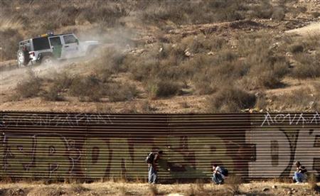 Immigrants hide from a border patrol vehicle while waiting a chance to cross into the United States at the border fence on the outskirts of the Tijuana, Mexico, September 19, 2009. REUTERS/Jorge Duenes
Immigrants hide from a border patrol vehicle while waiting a chance to cross into the United States at the border fence on the outskirts of the Tijuana, Mexico, September 19, 2009. REUTERS/Jorge Duenes