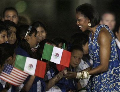 
First lady Michelle Obama (R) smiles as she is greeted by children upon her arrival at Benito Juarez International Airport in Mexico City April 13, 2010. Obama is in Mexico on a three-day visit. REUTERS/Henry Romero
