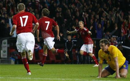Denmark's Jakob Poulsen (7) celebrates after scoring with teammates Michael Silberbauer (L) and Lars Jacobsen as Sweden's Kim Kallstrom (R) sits on the pitch during their World Cup 2010 qualifying soccer match in Copenhagen October 10, 2009. REUTERS/Bob Strong
Denmark's Jakob Poulsen (7) celebrates after scoring with teammates Michael Silberbauer (L) and Lars Jacobsen as Sweden's Kim Kallstrom (R) sits on the pitch during their World Cup 2010 qualifying soccer match in Copenhagen October 10, 2009. REUTERS/Bob Strong