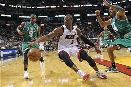 
Miami Heat guard Dwyane Wade (C) dribbles past Boston Celtics defenders Rajon Rondo (L) and Paul Pierce (R) in the second half of Game 4 of their Eastern Conference basketball playoff series in Miami, April 25, 2010. REUTERS/Joe Skipper
