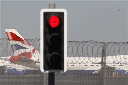
A British Airways aircraft manoeuvres behind a red traffic light at Heathrow Airport, west of London May 24, 2010. REUTERS/Stefan Wermuth
