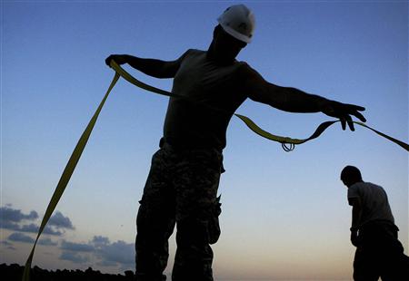 Louisiana National Guardsmen unravel support straps far a Tiger Dam, to protect the Grand Isle from encroaching oil coming in with the high tide in Grand Isle, Louisiana May 31, 2010. REUTERS/Sean Gardner
Louisiana National Guardsmen unravel support straps far a Tiger Dam, to protect the Grand Isle from encroaching oil coming in with the high tide in Grand Isle, Louisiana May 31, 2010. REUTERS/Sean Gardner