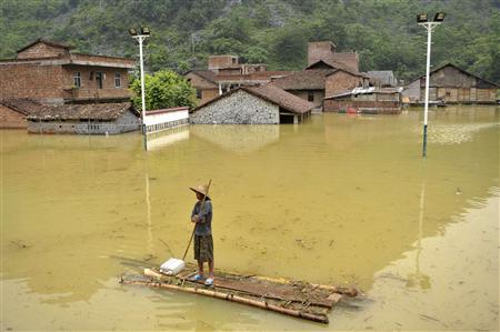 A resident stands on his makeshift raft at a flooded village on the outskirts of Xincheng county, Guangxi Zhuang autonomous region, June 4, 2010. REUTERS/Stringer
A resident stands on his makeshift raft at a flooded village on the outskirts of Xincheng county, Guangxi Zhuang autonomous region, June 4, 2010. REUTERS/Stringer