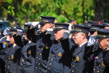 Firefighters salute at a memorial service. Firefighters salute at a memorial service.
