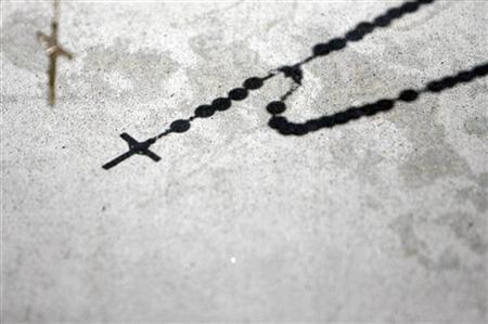 
A protestor recites the rosary outside the Cathedral of Our Lady of the Angels in Los Angeles July 15, 2007. REUTERS/Mario Anzuoni
