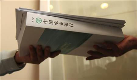
A potential investor collects application forms and a Agricultural Bank of China prospectus during its initial public offering (IPO) in Hong Kong June 30, 2010. REUTERS/Tyrone Siu
