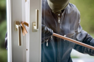 A burglar breaking into a house.