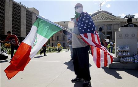 A protester with a U.S. flag and a Mexican flag stands outside the Arizona State Capitol in Phoenix, Arizona April 23, 2010 in protest of an immigration law signed by Arizona Governor Jan Brewer. REUTERS/Laura Segall
A protester with a U.S. flag and a Mexican flag stands outside the Arizona State Capitol in Phoenix, Arizona April 23, 2010 in protest of an immigration law signed by Arizona Governor Jan Brewer. REUTERS/Laura Segall