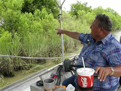 Cattle rancher Philip Simmons uses a flatboat to access his cattle on the banks of the Mississippi River near Point Pleasant, Louisiana July 17, 2010. REUTERS/Alexandria Sage
Cattle rancher Philip Simmons uses a flatboat to access his cattle on the banks of the Mississippi River near Point Pleasant, Louisiana July 17, 2010. REUTERS/Alexandria Sage