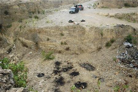 
The site of a mass grave with some charred spots (rear) is seen in the suburb of Juarez, neighbouring Monterrey, July 22, 2010. Forensic investigators and the military found the remains of at least fifty people so far, suspected to be victims of drug crimes, in one of two mass graves discovered on Thursday in this municipality, according to local media. Picture taken July 22, 2010. REUTERS/Stringer
